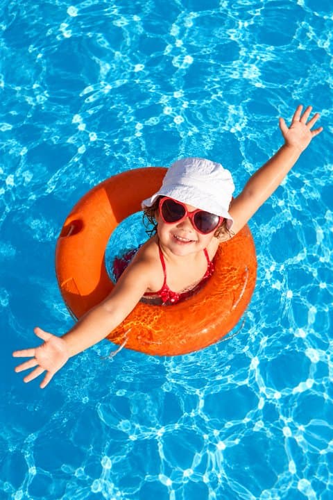 Kid floating in a pool with an inflatable ring